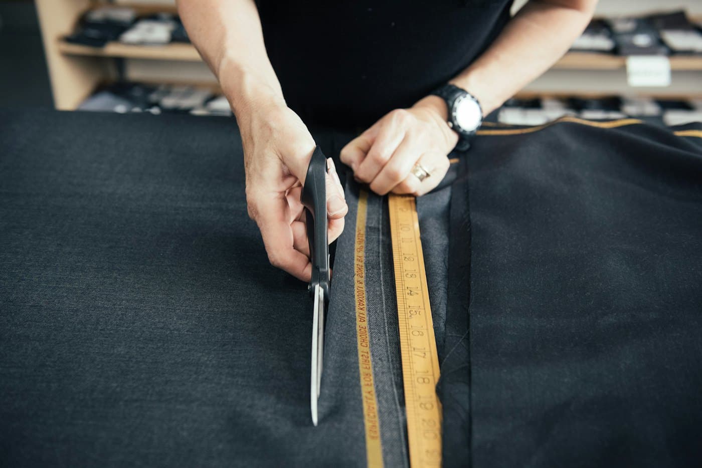 Tailor measuring and cutting dark wool
